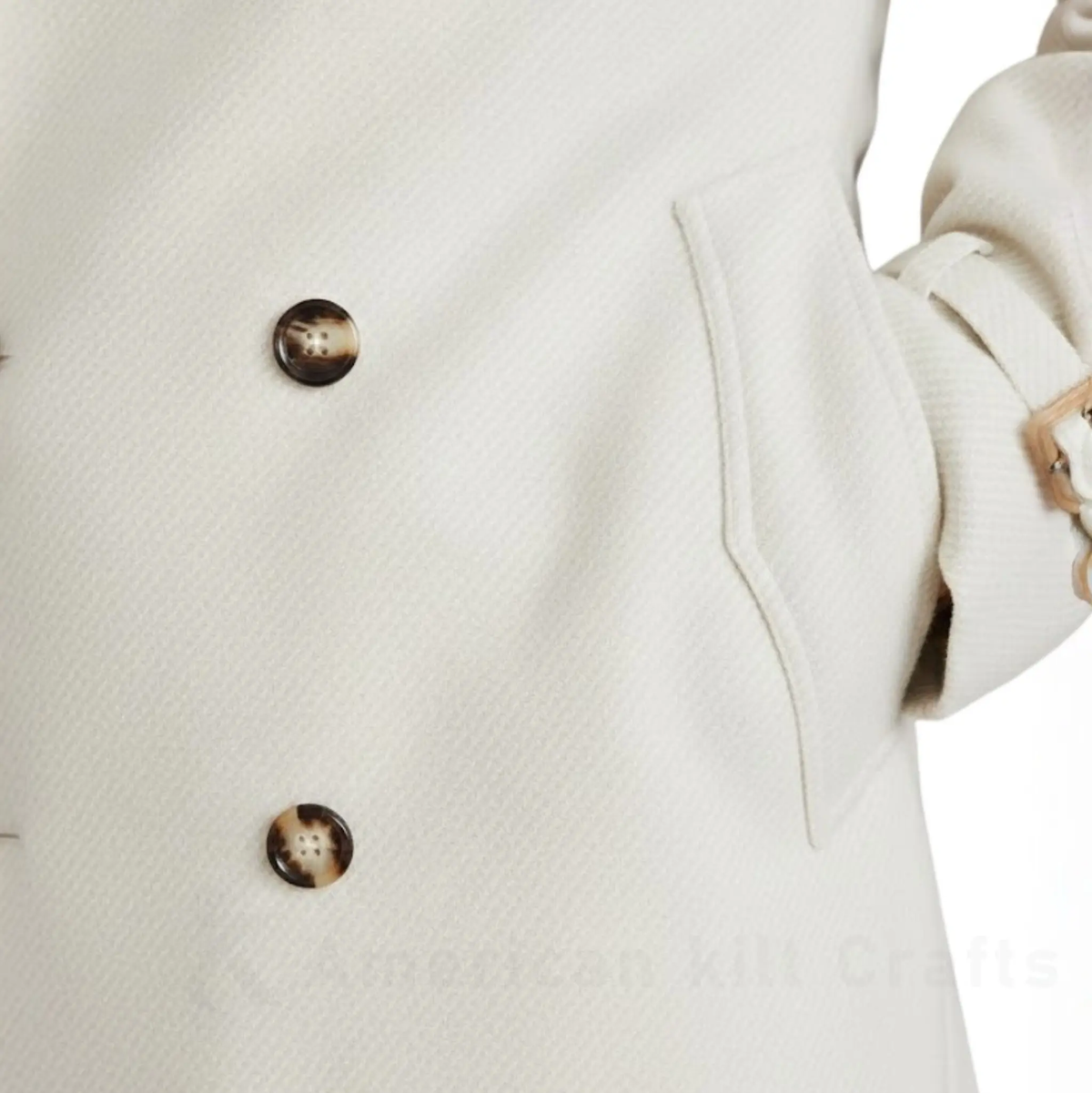 Close-up of an elegant women’s long double-breasted trench coat showing the buttons, stitching and tailored outerwear details.