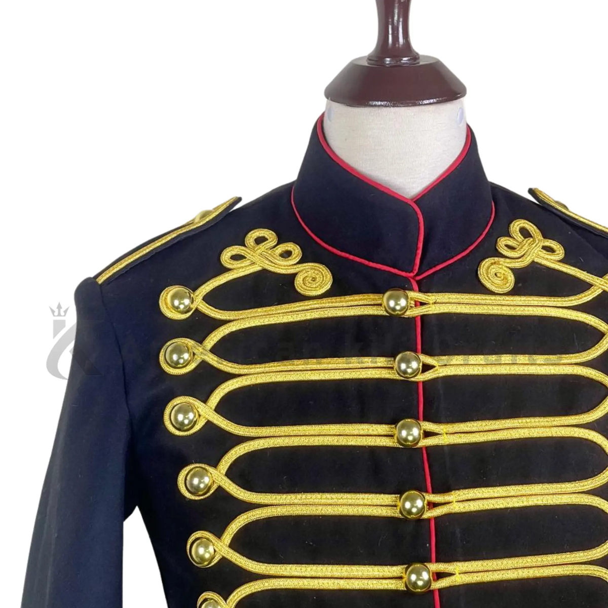 Close-up of British Hussar military jacket showing detailed gold braiding, decorative buttons, black fabric, red trim, and historical uniform craftsmanship.