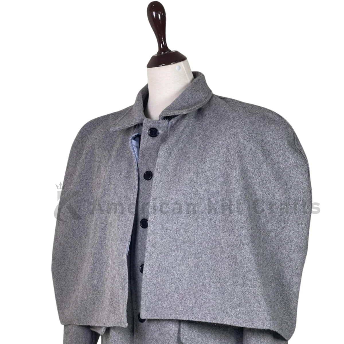 Close-up of men’s grey wool Inverness cape showing the collar, front fastening, layered cape construction and textured wool fabric detailing.