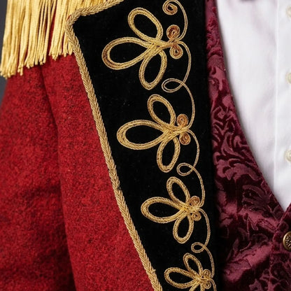 Close-up of men’s red Ringmaster tailcoat showing detailed gold embroidery, decorative buttons, and Victorian military-inspired craftsmanship.