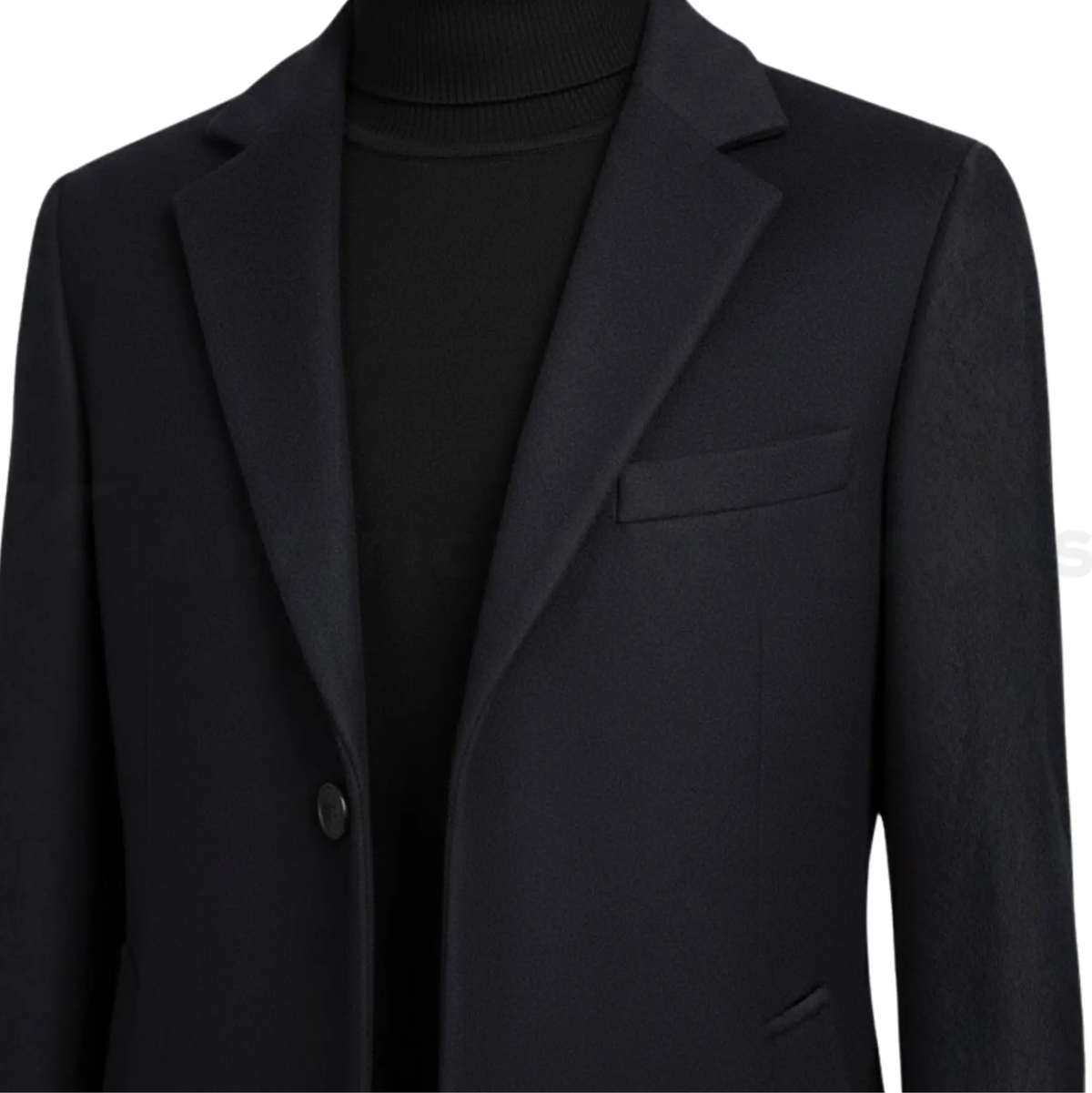 Close-up of men’s black single-breasted overcoat showing notched lapel, button detail, smooth fabric texture, and tailored slim fit finish.