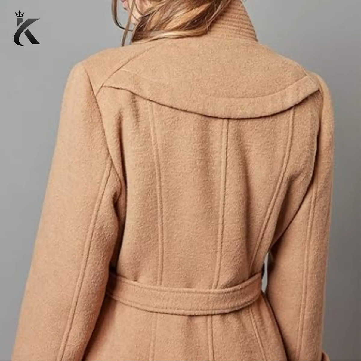 Back view of women’s long wool trench coat showing the tailored silhouette, structured shoulders, belt detailing, and elegant winter coat design.