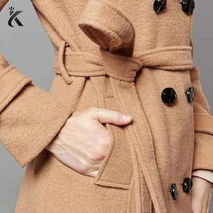 Close-up of women’s wool trench coat showing the double-breasted buttons, lapel collar, belt details, and premium tailored finish.